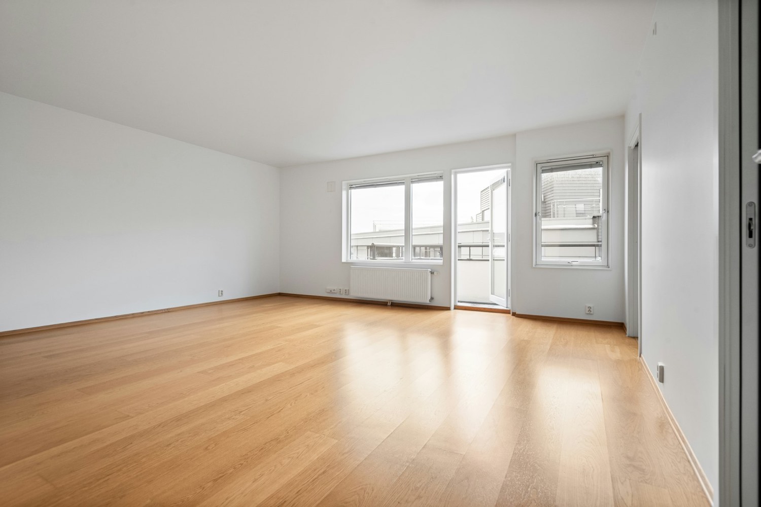 Empty room with light wood floors, white walls, and white baseboards